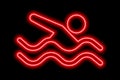 Neon red silhouette of freestyle swimmer with waves on black background