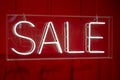 Neon sale sign sparkling in a red shop-window