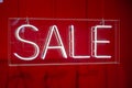 Neon sale sign sparkling in a red shop-window