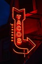 A neon sign advertising tacos