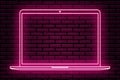 A neon sign in the form of a laptop. Pink color. Against the background of a brick wall with a shadow.