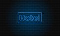 Neon sign hotel on brick wall background. Vintage electric signboard with bright neon lights. Blue light falls on a brick Royalty Free Stock Photo