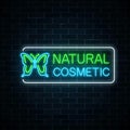 Neon sign of natural cosmetic production with butterfly on dark brick wall background.