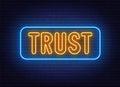 Neon sign Trust on brick wall background.