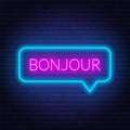 Neon sign of word bonjour in speech bubble frame on dark background. Greetings in French.