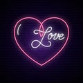 Neon sign, the word Love with heart on dark brick wall.