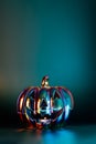 Neon spooky halloween pumpkin, Jack O Lantern, with an evil face and eyes made with holographic glass on dark green background