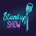 Neon stand up show mic with handwritten lettering. Night illuminated wall street sign.