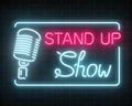 Neon stand up show sign with retro microphone on a brick wall background. Comedy battle glowing signboard.