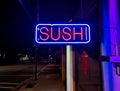 A neon sushi sign in front of a Japanese restaurant. Royalty Free Stock Photo