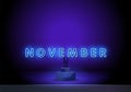 Neon symbol for November : Month Name with colorful elements. November on a stand. Neon glowing lettering on a dark wall