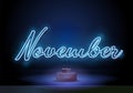 Neon symbol for November : Month Name with colorful elements. November on a stand. Neon glowing lettering on a dark wall