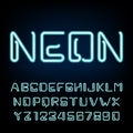 Neon tube alphabet font. Futuristic type letters and numbers on a dark background. Royalty Free Stock Photo