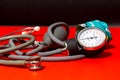 Neonatal stethoscope and Pediatrics sphygmomanometer on red with black background, children and newborn blood pressure