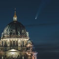 Neowise Comet visible in city of Berlin over Berlin Cathedral with illuminated night sky. Astro photo during night time