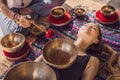 Nepal Buddha copper singing bowl at spa salon. Young beautiful woman doing massage therapy singing bowls in the Spa