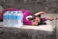 Nepal, Kathmandu city, Swayambhunath Stupa, water seller sleeping on the street and her baby