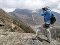 Photographer stands on the slope of mountain in Himalayas