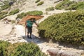 Nepalese sherpa porter walks on footpath carrying heavy load Royalty Free Stock Photo