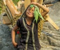 Nepalese little girl carry big basket with wood logs