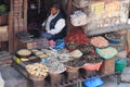 Nepalese man street seller selling dried red chili peppers and dried fish