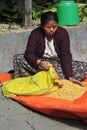 Nepalese peasant woman sorts grain in a small village in the vic