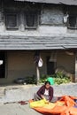 Nepalese peasant woman sorts grain in a small village in the vic