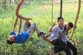 Nepalese poor children boys play and have fun wallowing a fool on a tree