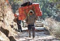 Nepalese porter carrying a heavy load in Nepal Himalayas Royalty Free Stock Photo