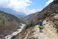 Nepalese sherpa porters walks on footpath carrying heavy load