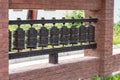 Nepalese traditional metal prayer wheels hanging in a row