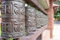 Nepalese traditional metal prayer wheels hanging in a row