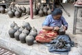 Nepalese woman making pottery in Pottery square, a public square full of pottery wheels and rows of clay pots