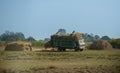 Nepalese workers loads haystacks on truck.