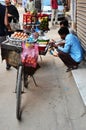 Nepali man vendor push bicycle cart hawker on road sale variety fruits and food to nepalese people and foreign travelers eat drink