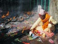 Nepali man wearing traditional dress burns candles in Dakshinkali Hindu temple in Pharping, Nepal. Royalty Free Stock Photo