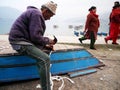 Nepali old man carpenter or repairman senior nepalese people working repair wooden boat beside of Phewa Tal or Fewa Freshwater