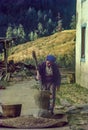 Nepali woman pounding the rice