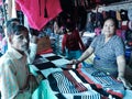 a Nepali woman selling woolen sweater to the indian male customer at garment store in india dec 2019