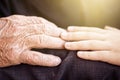 Nephew touching grandfather's hand in sunlight