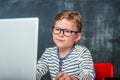 Nerd child in glasses using a laptop computer. Kid has online lesson. Back to school Royalty Free Stock Photo