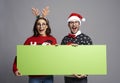 Nerd couple holding greenscreen Christmas banner