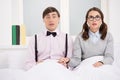 Nerd couple. Surprised nerd couple sitting on the bed and looking at camera Royalty Free Stock Photo
