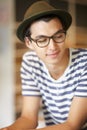 Nerd, man and thinking with a smile in home with ideas of future, growth and daydream with hope. Hipster, person and Royalty Free Stock Photo