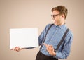 Nerd pointing at blank card against cream background Royalty Free Stock Photo