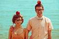 Nerds` honeymoon concept. Portrait of couple of young happy married hipsters in trendy vintage clothes standing together on the Royalty Free Stock Photo