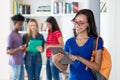 Nerdy female student working with tablet computer with group of multi ethnic college students Royalty Free Stock Photo