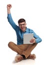 Nerdy student celebrates very good news he reads on tablet