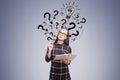 Nerdy woman near dark gray wall with question marks Royalty Free Stock Photo