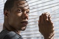 Nervous African American man at window, horizontal